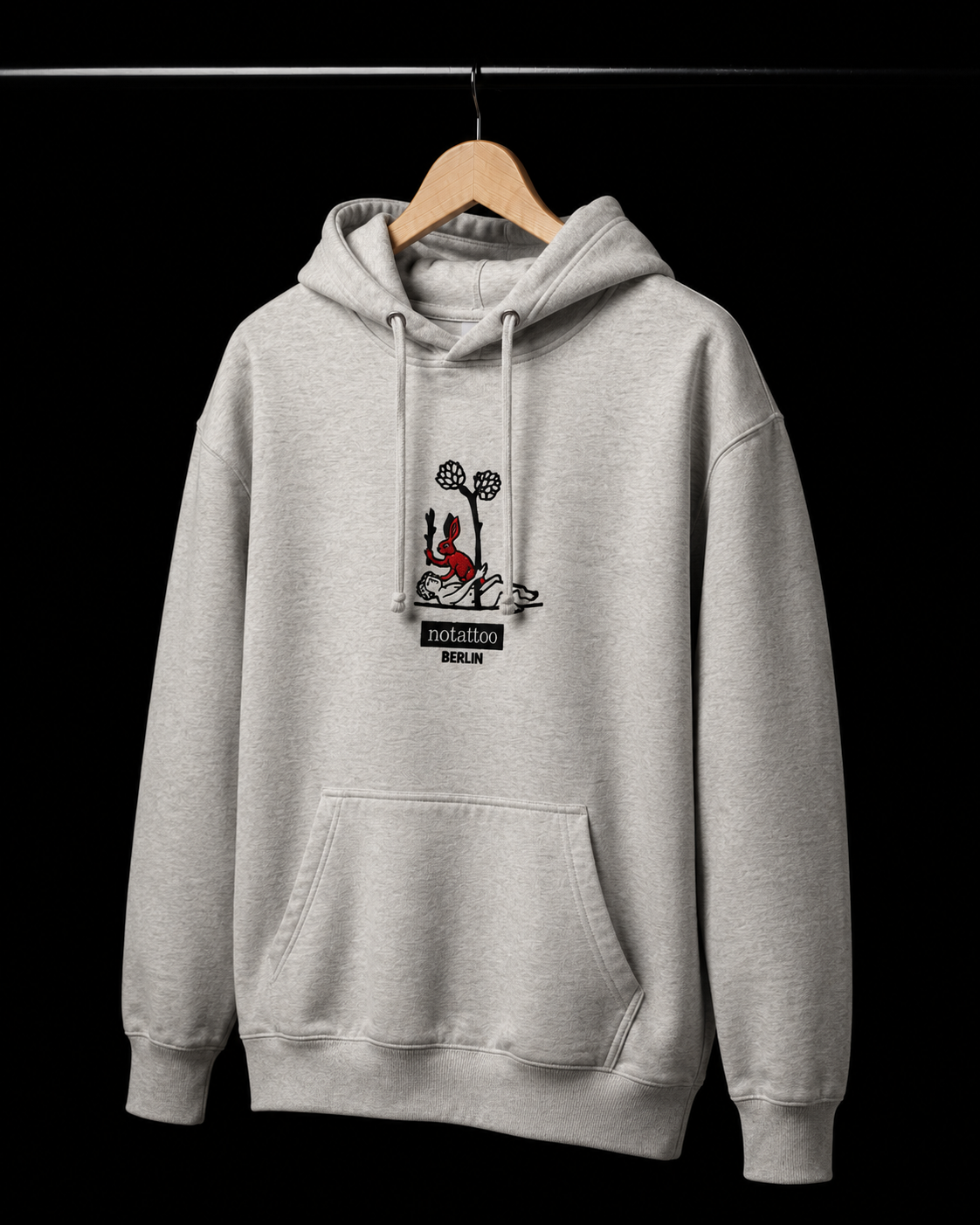 Basic Grey Medieval Killer Rabbit Hoodie hanging on a wooden hanger, featuring embroidered rabbit artwork inspired by medieval imagery and tattoo culture.