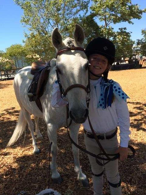 Young rider hair should be pulled out of the face. Often girls wear braids with show bows. A great selection can be found here .