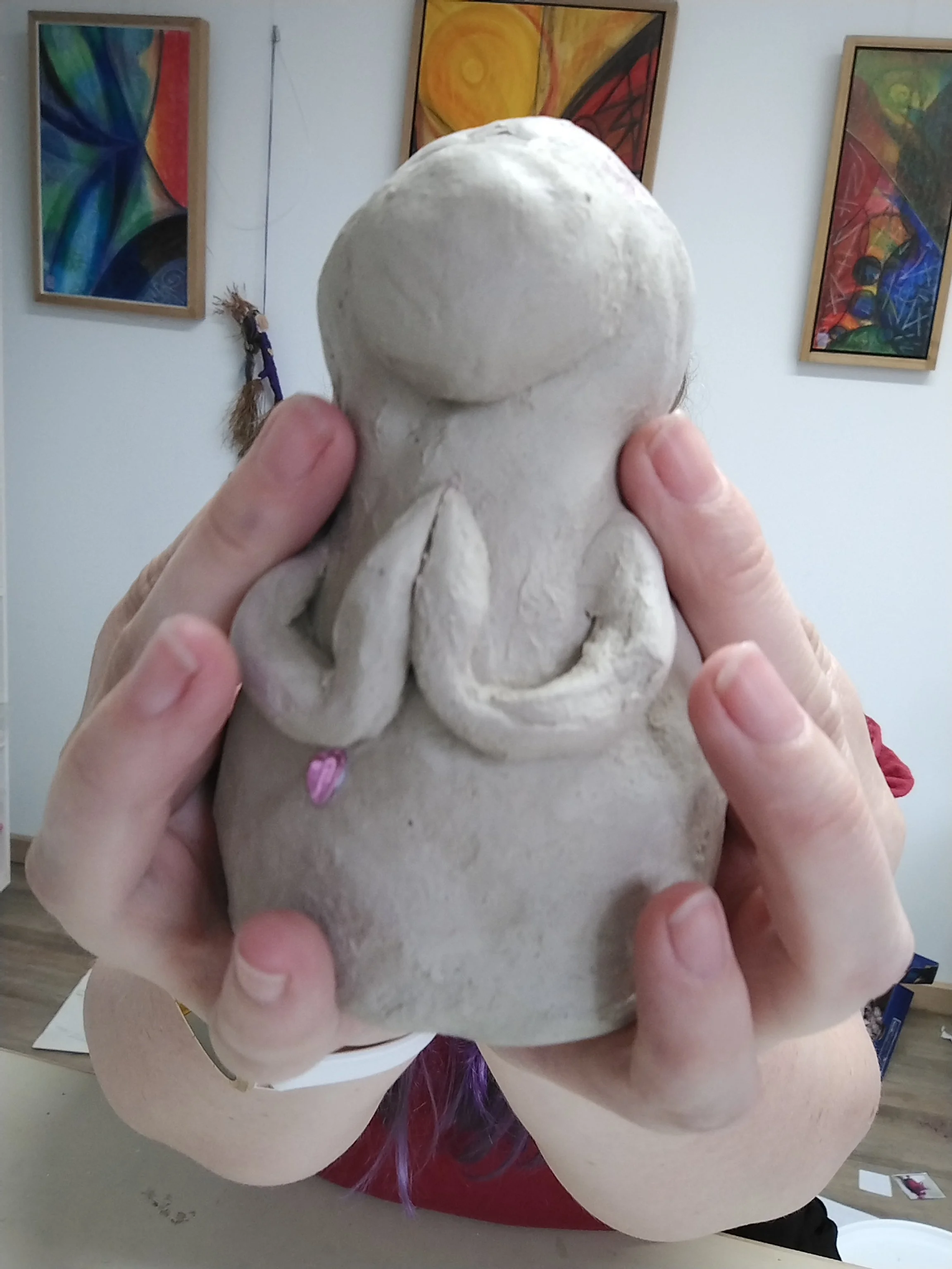 Person holding a small clay sculpture of a praying woman symbolising love, hope and gratitude as well as connection within. Created as an art therapy exercise, inner healing and connection offered in Ballarat by ART from SPIRIT.