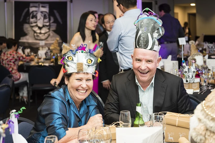 Image: Two employees of Liberty International Underwriters wear animal-inspired party hats created by the Props Collective for their Christmas party held at Taronga Zoo.