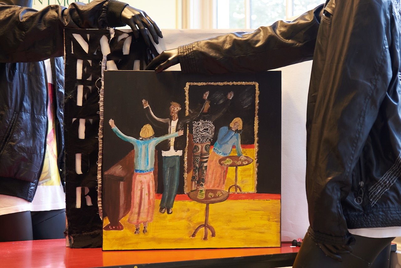 painting by simon o’corra.depicting a coming out for which i posed as one can see from the tattoos on the legs in the mirror.