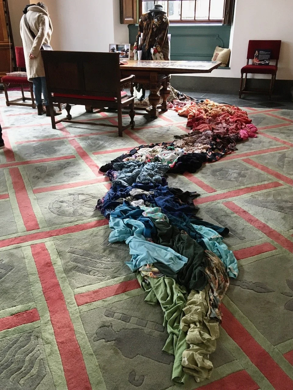  a train of clothes as part of a project for george moormann (poet). his mother made all these clothes.   all shirts and skirts are hand stitched together in squares with cross stitches. every single piece  can still be worn dragging behind you the r