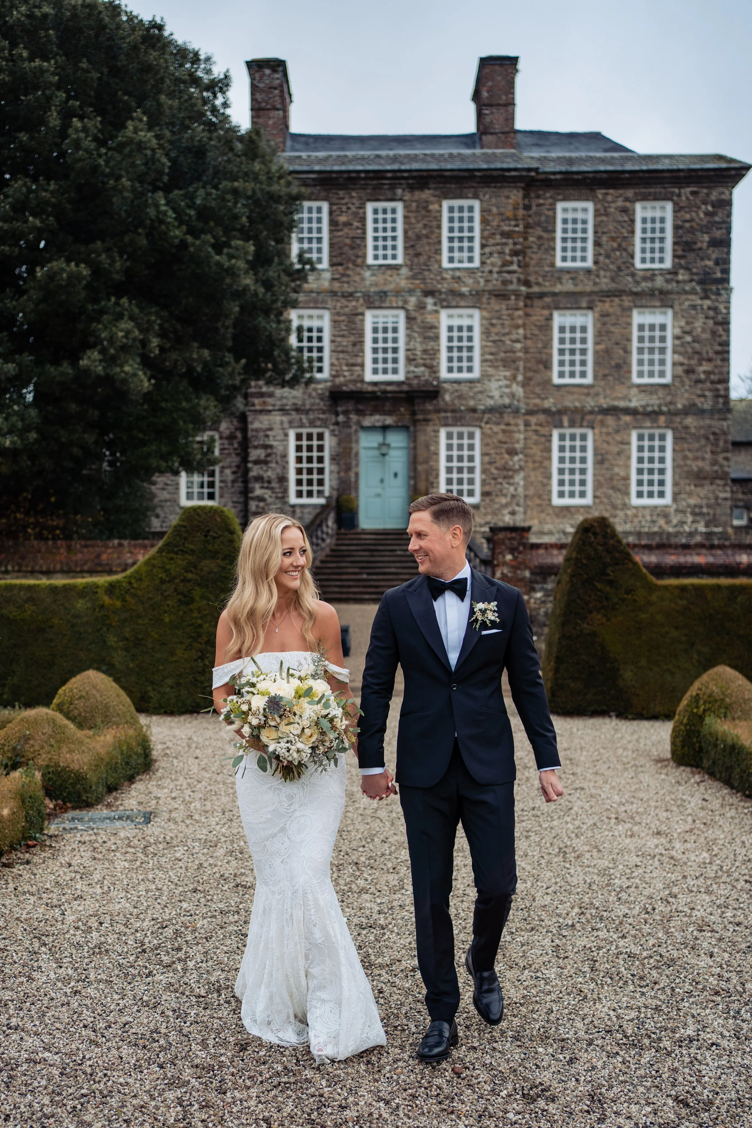 bride and groom walking away from kingston estate devon