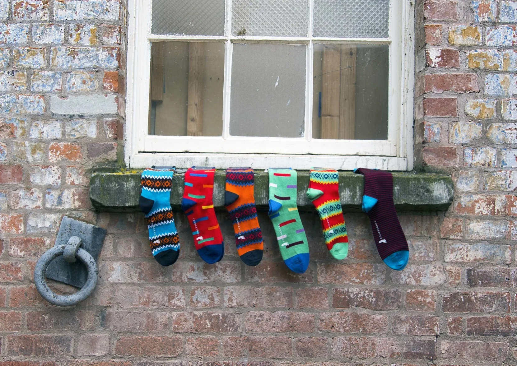 Line of coloured men's socks on windowsill Hereford.jpg