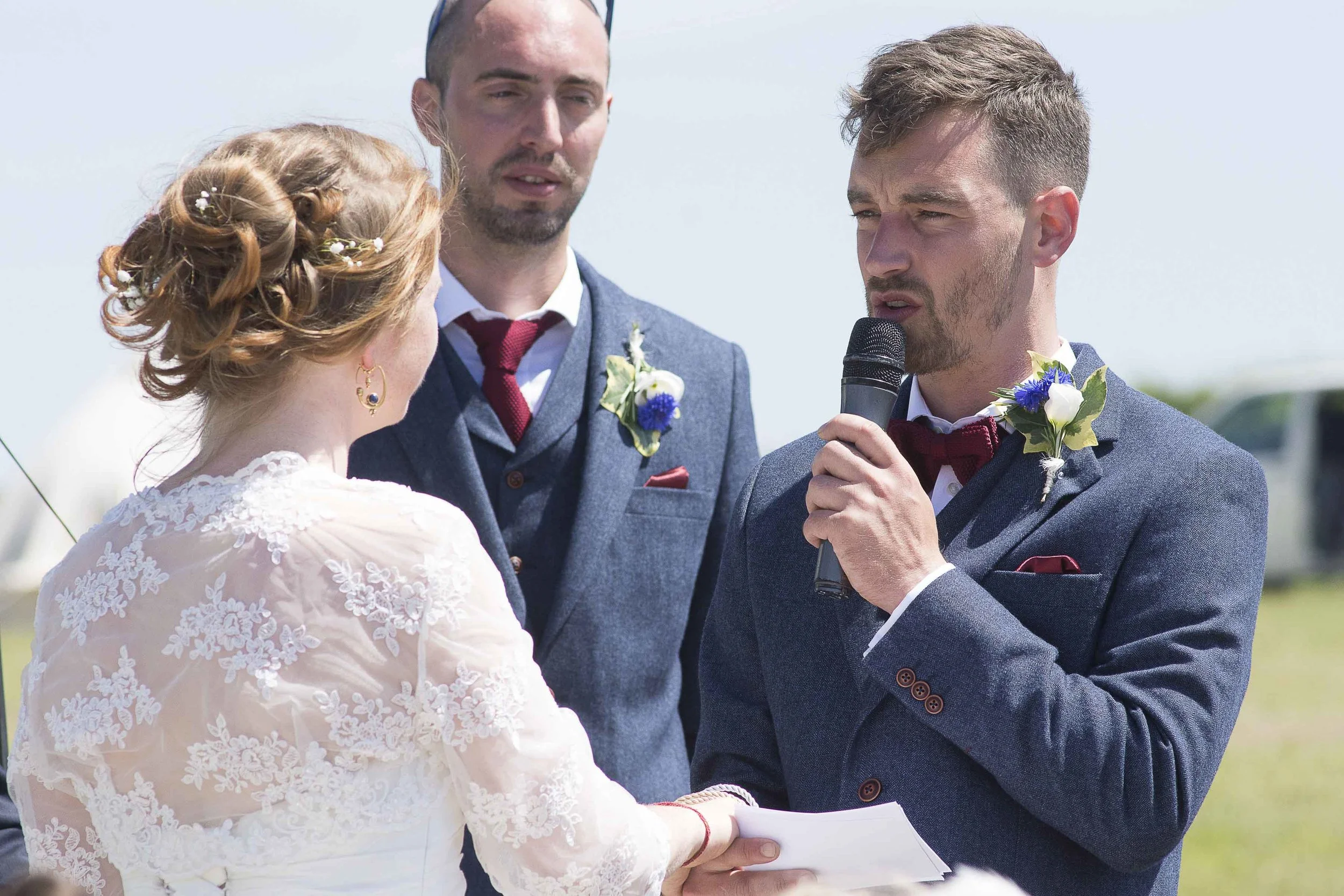Groom speaking on a microphone to his bridge