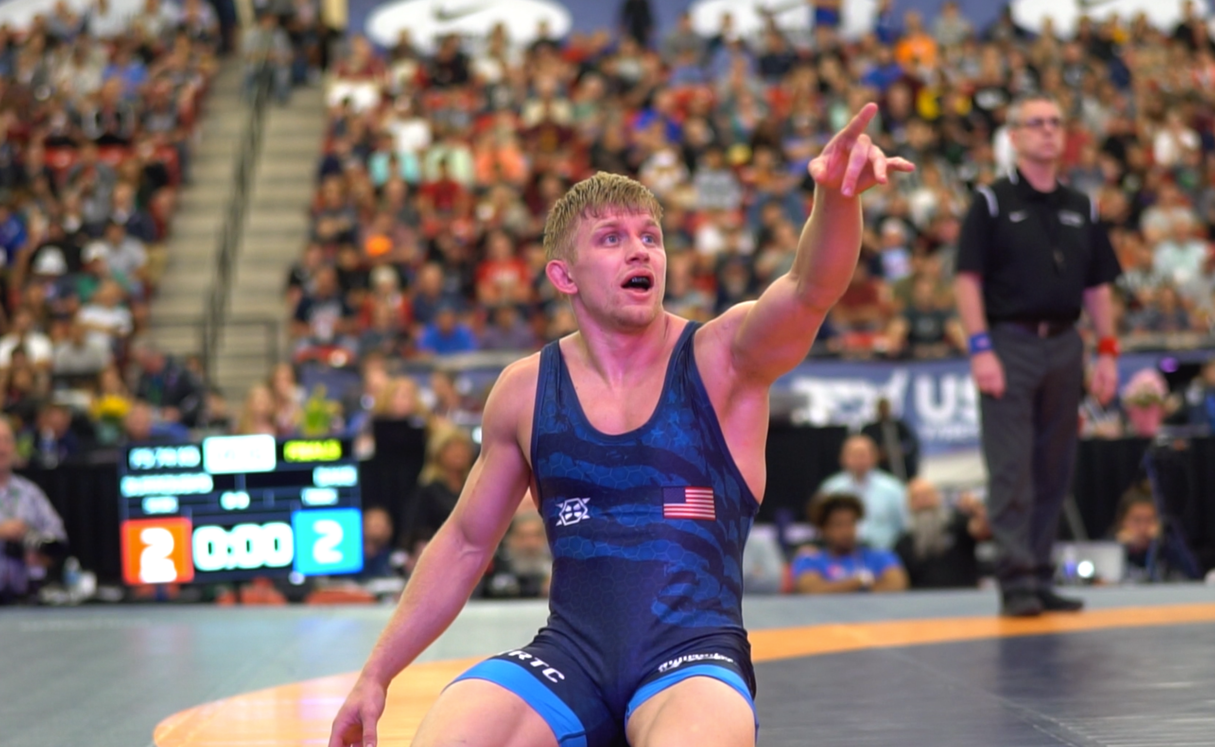 Kyle Dake points to the replay screen after his controversial loss to Jordan Burroughs in the Championship Finals of the 2017 U.S. Open. (screen grab of mat side footage)