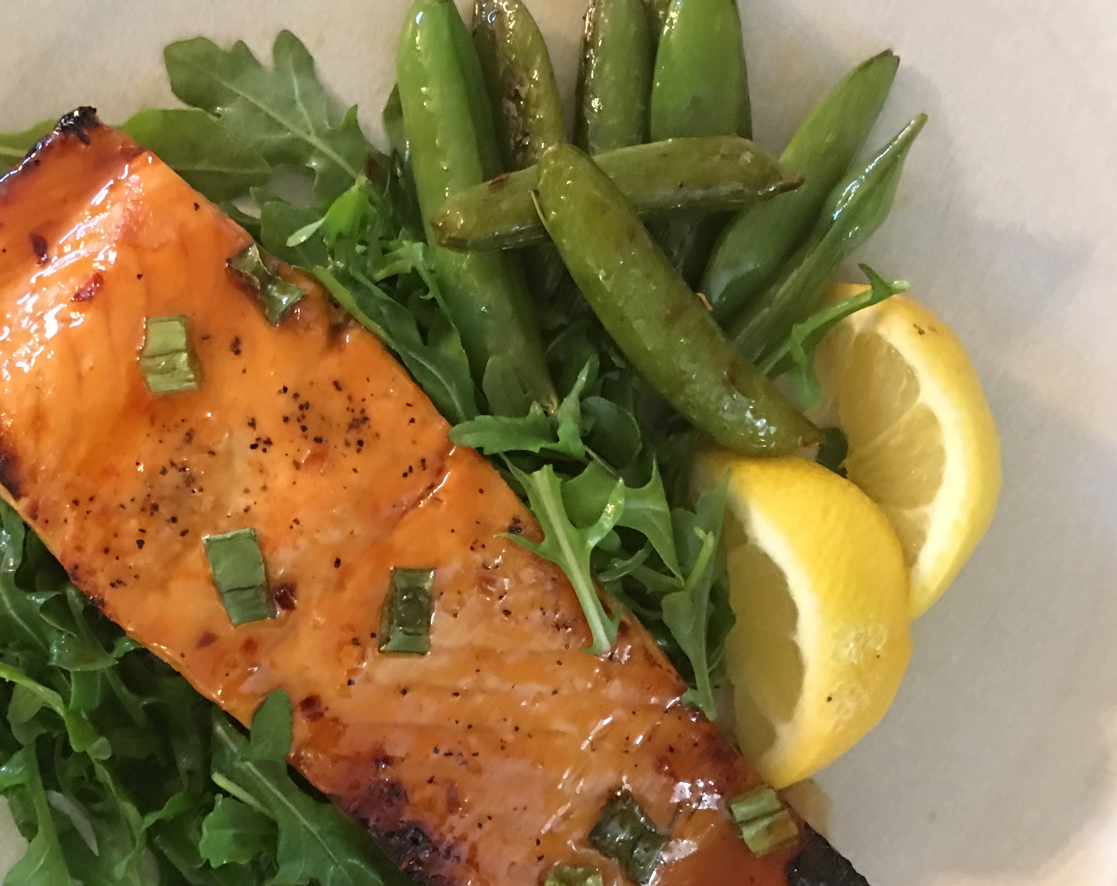 Salmon on bed of arugala with snap peas and lemon.jpg