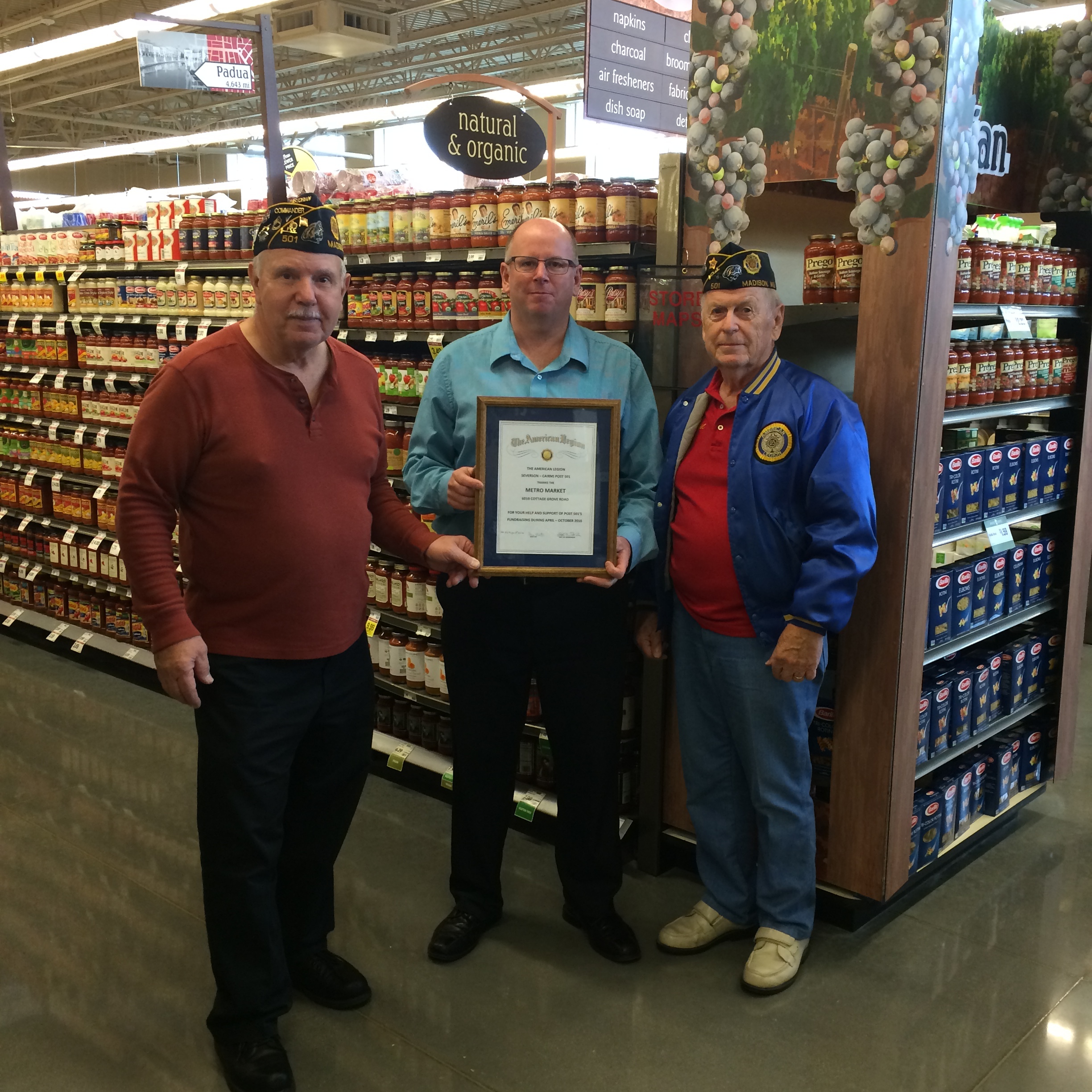 Certificate of Appreciation is presented to Tim Smits, Store Mgr., Metro Market, for their support of the Am. Legion Post 501 fund raising Brat Fests, by Post 501 Cdr, Tom Stolarczyk, and Phil Ingwell, Post 501 Finance Officer.