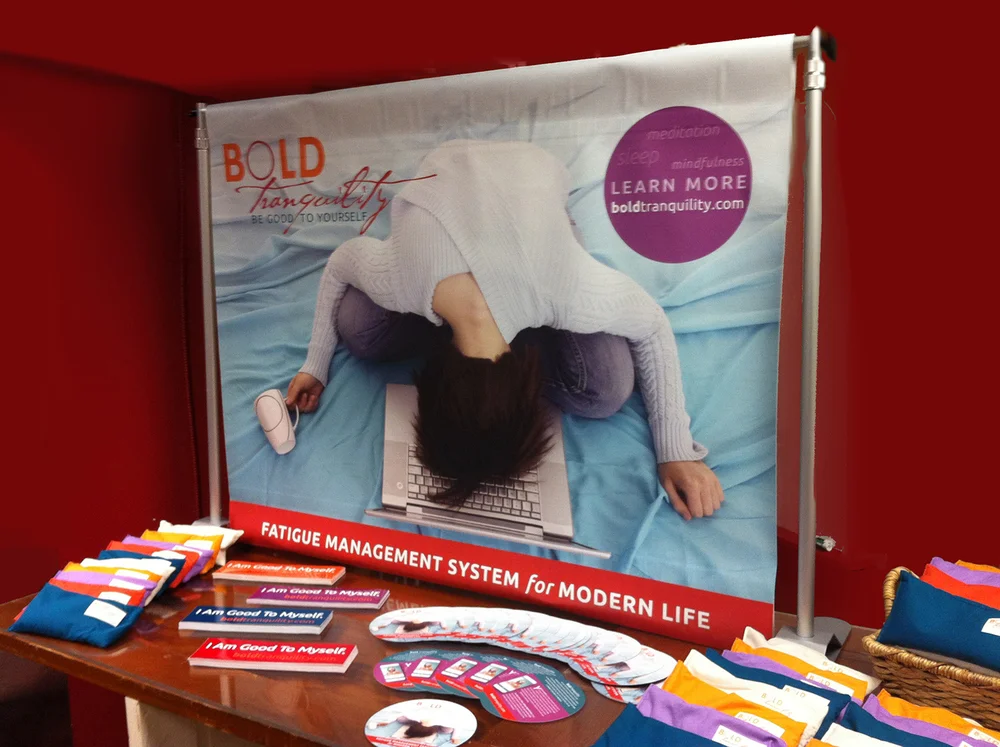 Promotional display unveiling Bold Tranquility with portable display banner, circular promotional postcards; bumper stickers; personalized eye cushions