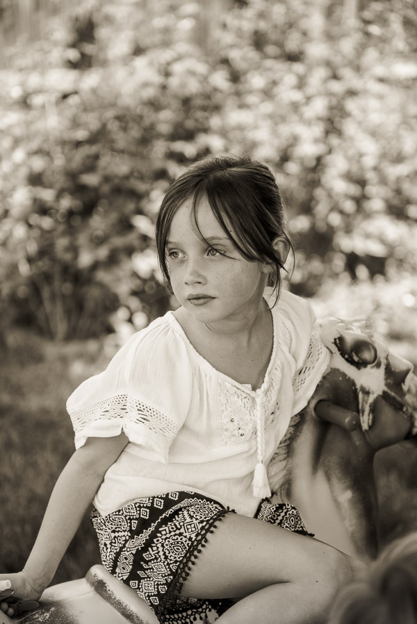 Beautiful young girl sitting backward on rocking horse.