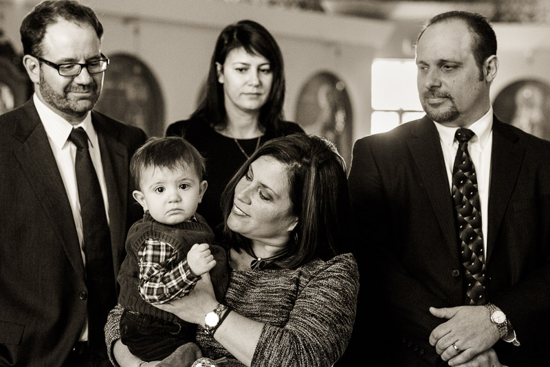 Godmother plays with godson during baptism