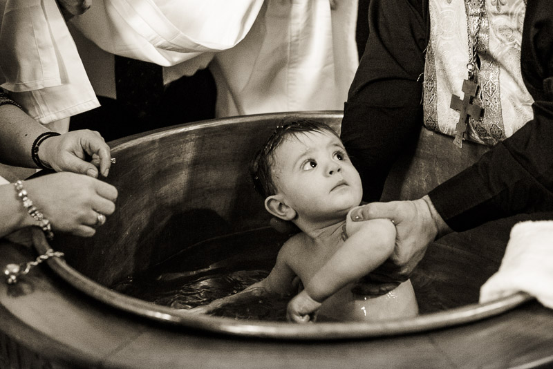 Baby boy in a Greek Orthodox batismal font in Denver.