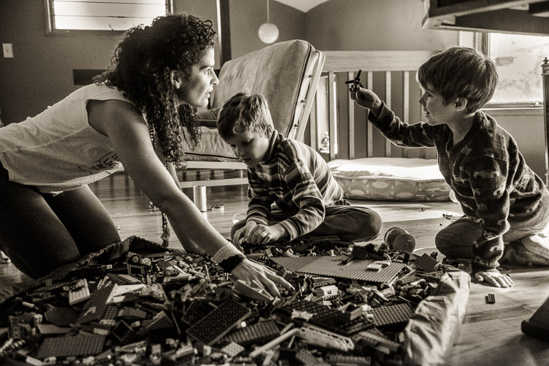 photo of woman and two boys playing with Legos
