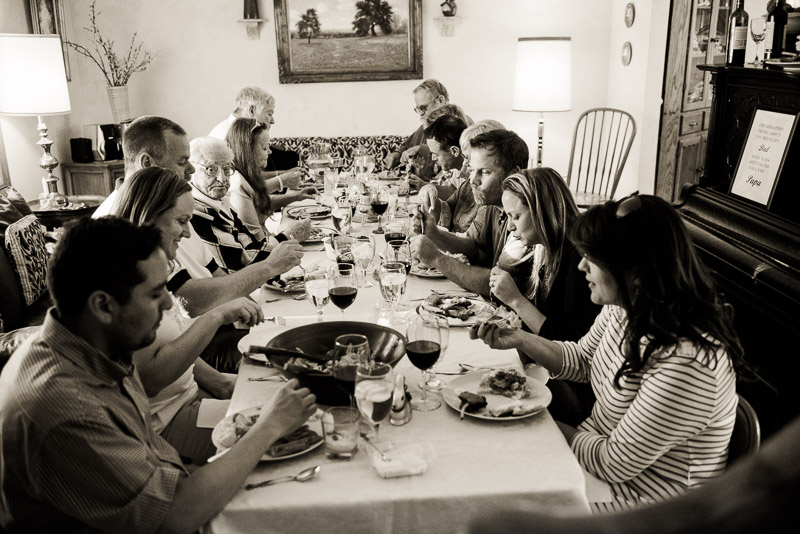 Thanksgiving documentary family photography Denver of everyone sitting at the dinner table eating.