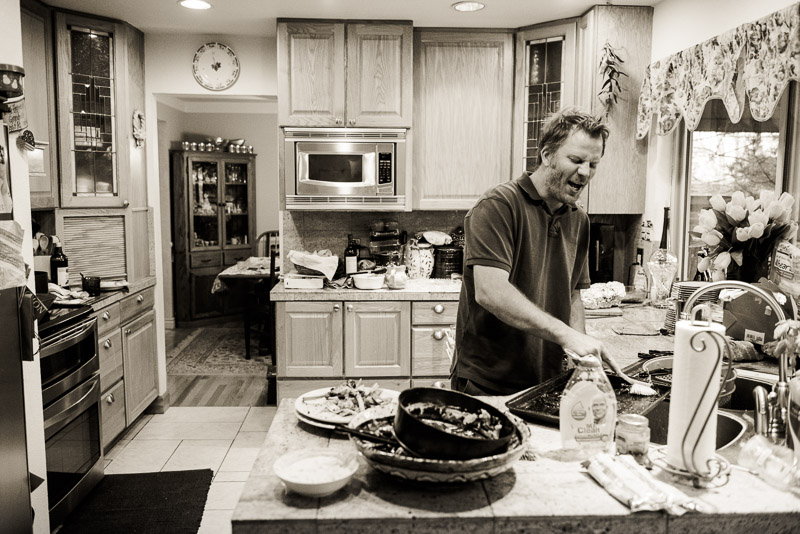 Man cleaning the dishes in the kitchen by himself.