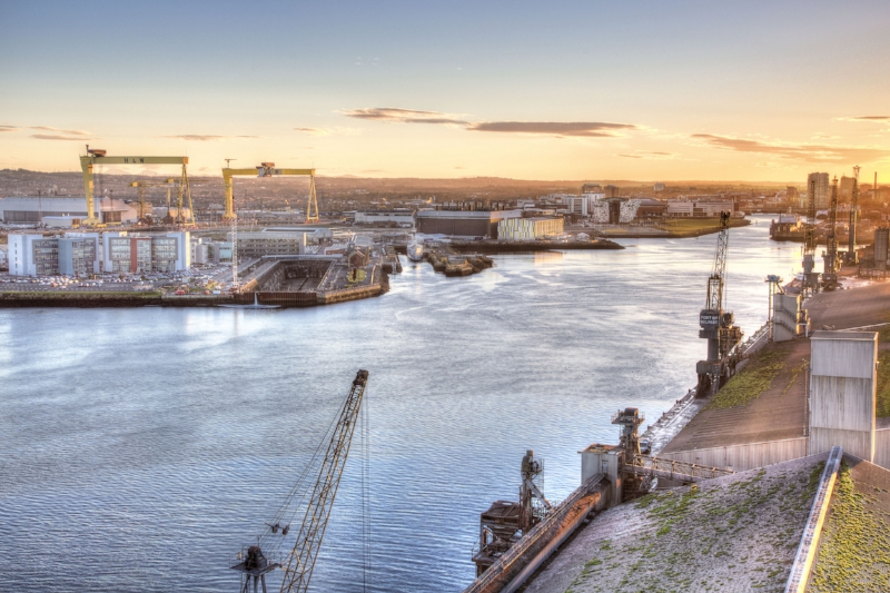 Grand View of the River Lagan, Belfast Harbour, the city itself and beyond. At Left are the gantry cranes of Harland & Wolff, Samson and Goliath ; below them is the Thompson Graving Dock, were Titanic was partly fitted out; to the right is Titanic Studios in the large brown building, and further over is Titanic Belfast and the slipways. Image Credit: Titanic Belfast via Flickr cc
