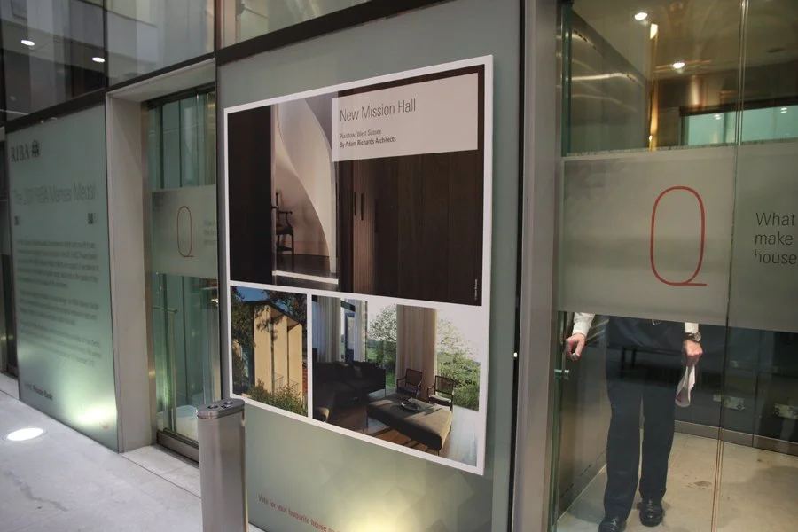 Photo montage outside of lifts with images of the winning houses from the 2011 RIBA Manser Medal award