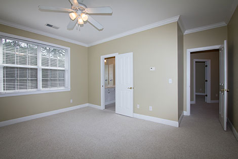 Notice the hard shadow under the ceiling fan? That's the classic give away that a photographer was using a single flash attached to the camera. Note also that the hallway, bathroom, and second bedroom look very dark. The lighting is hot in the middle and darker along the edges.