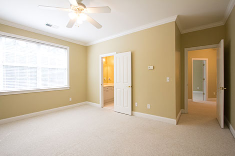 Wow, look at the those windows! It's like a nuclear bomb is going off outside. Can you tell there are blinds? Also, the lights on the ceiling fan are glowing and blown out. There is light in the bathroom and hallway, but they both look like the paint is orange instead of the same color as the bedroom.