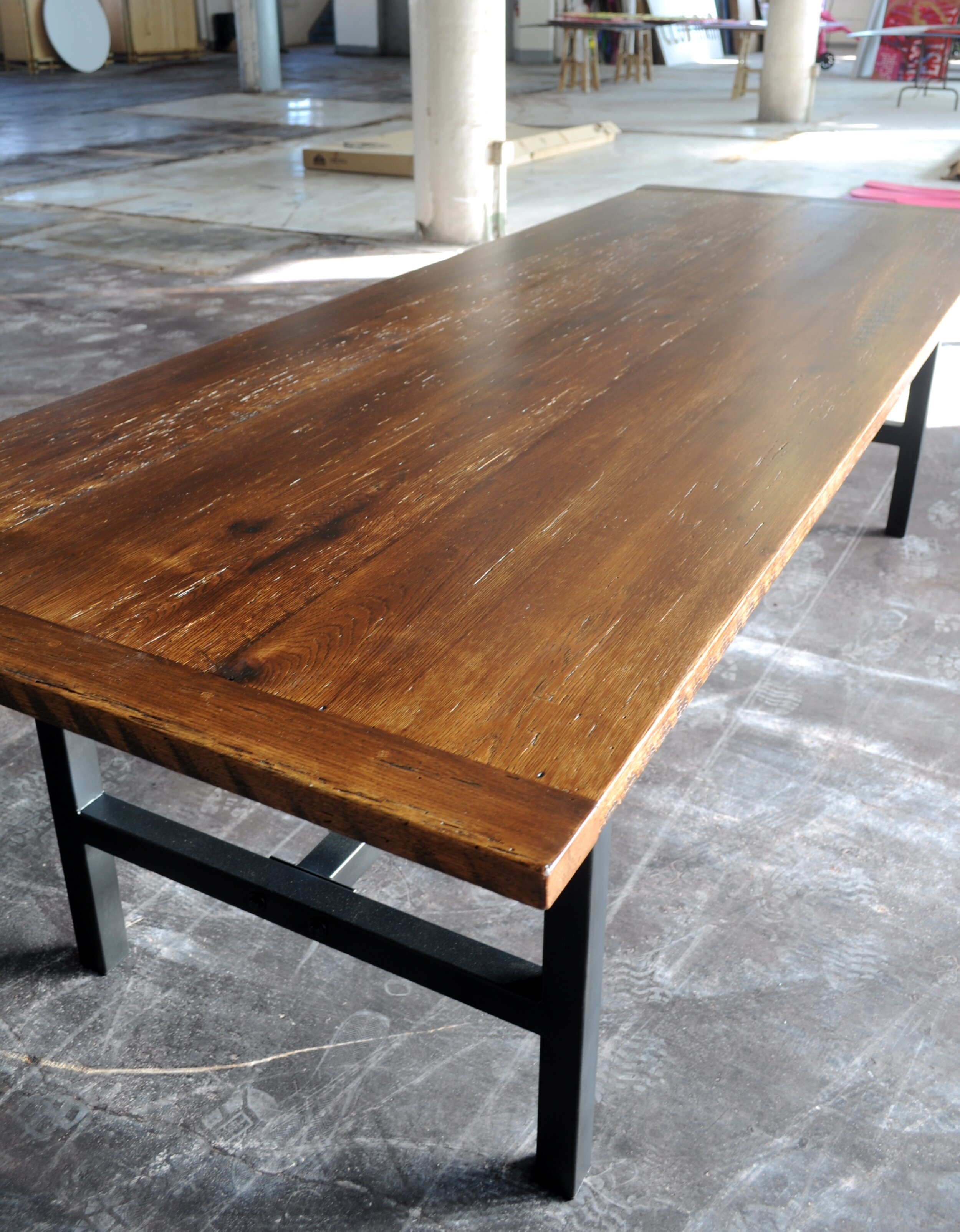 Wood and Steel Dining Table with reclaimed oak top on steel base, three-quarter end view