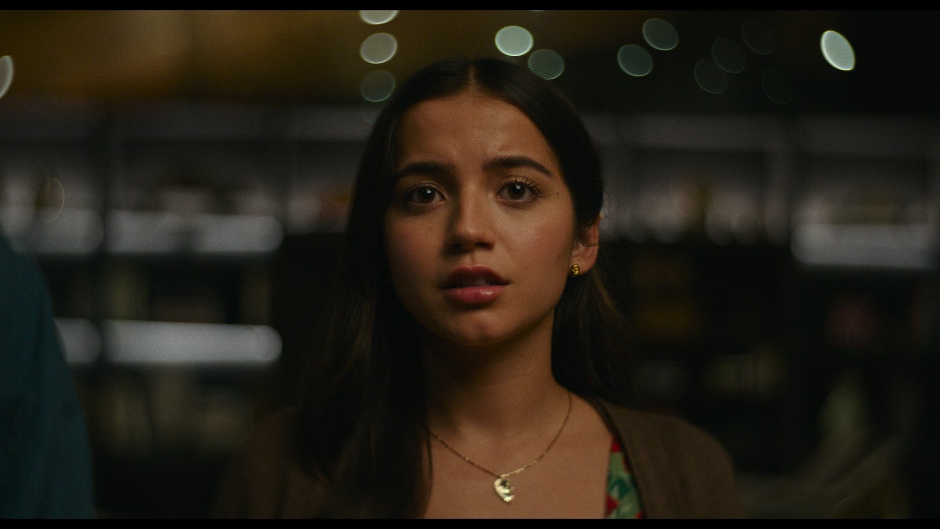 Film still: Isabela Merced as Aza, very moved by something we can't see.