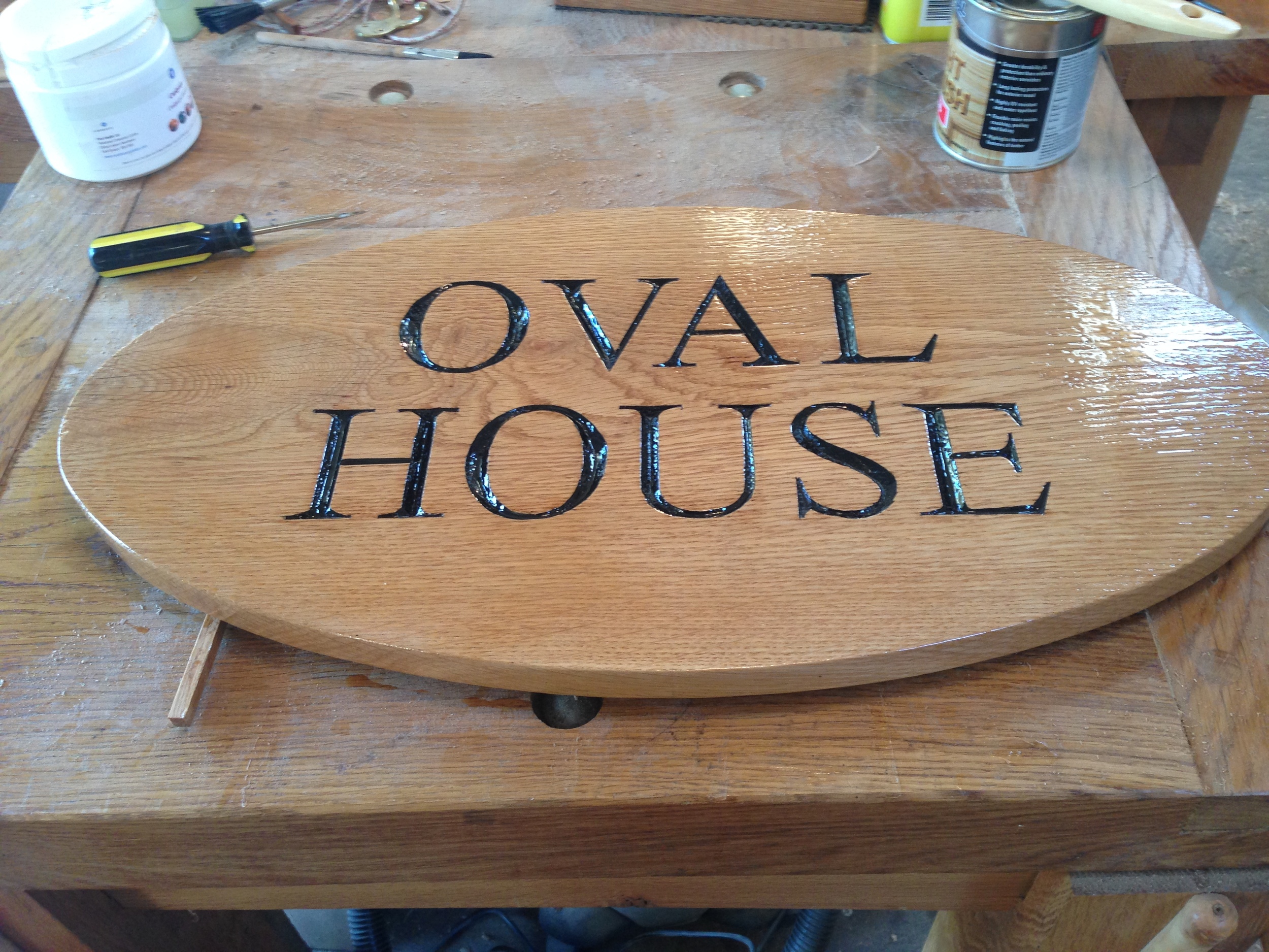 An "Oval" sign in oak