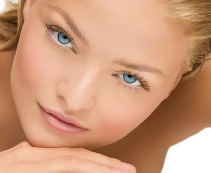 A blue-eyed girls face glares at the camera from close range.