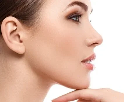 A woman touches her chin, testing its curvature.