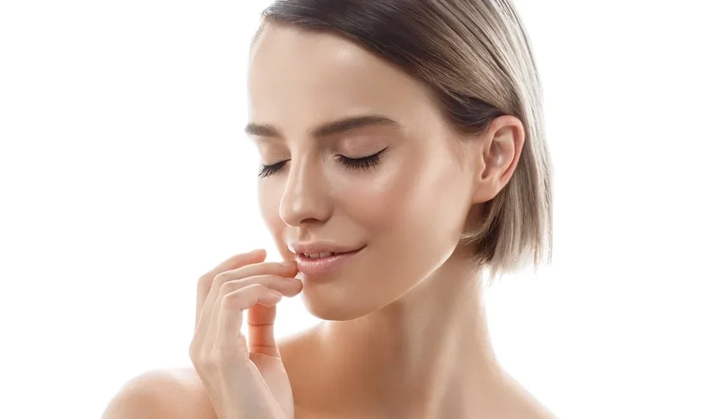 A beautiful woman closes her eyes while touching her lower lip.