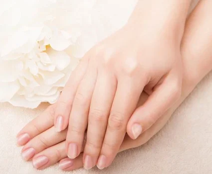 A couple of well-maintained hands rest upon each other.