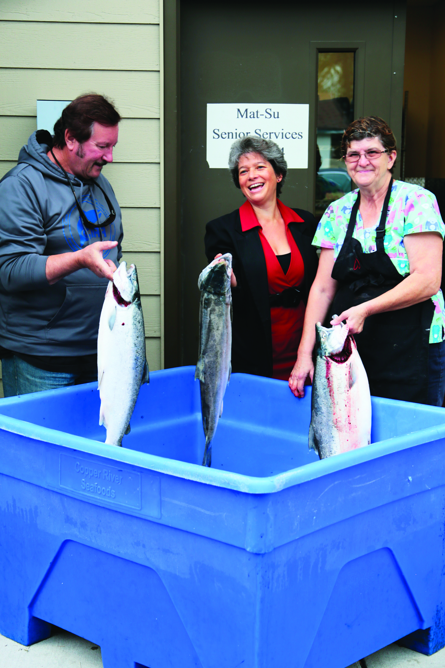 Bob Cellers of Northern District Setnetters, Mat-Su Senior Services Director, Rachel Greenberg, and Mat-Su Senior Services cook, Phyllis Moore. admire ‘Silvers for Seniors”.