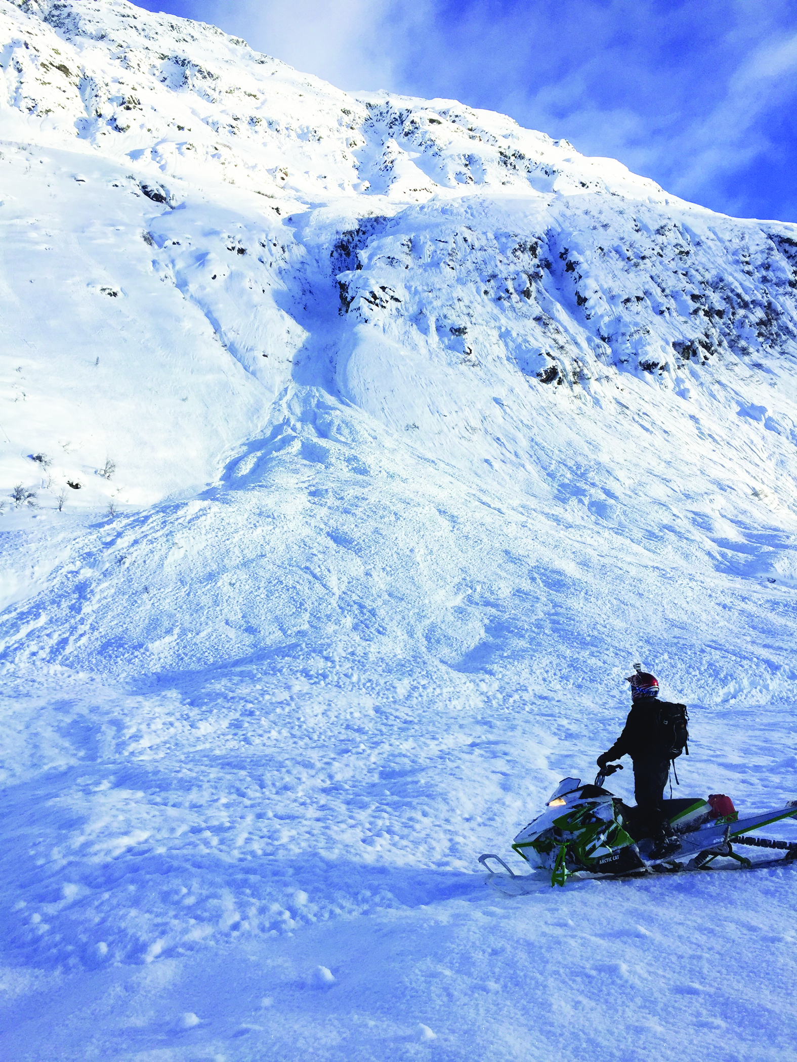 A snowmobile checks out the run out zone from an Avalanche in Hatcher Pass. Photo by S. Carter