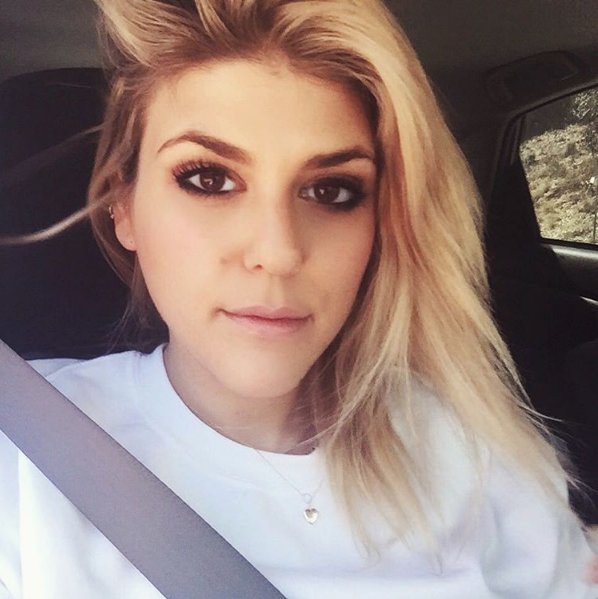 It appears Molly is in a car. It also appears she cares about her safety and her eyebrows.