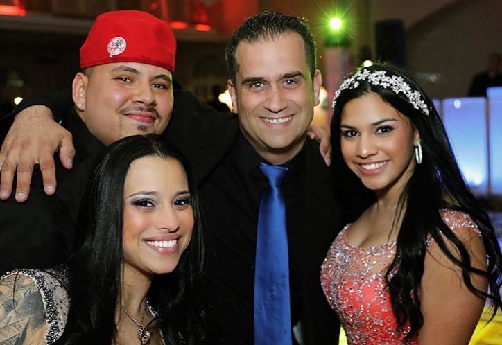 Four people at a celebration, two women and two men, dressed up and smiling