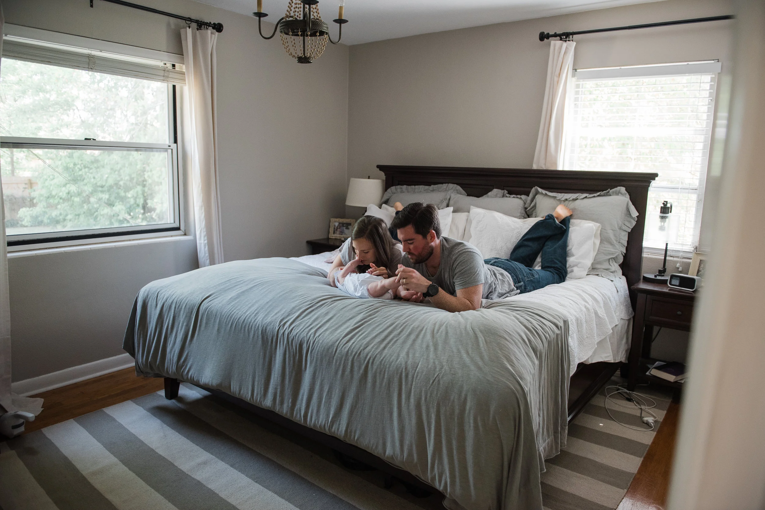 mom and dad on bed with baby