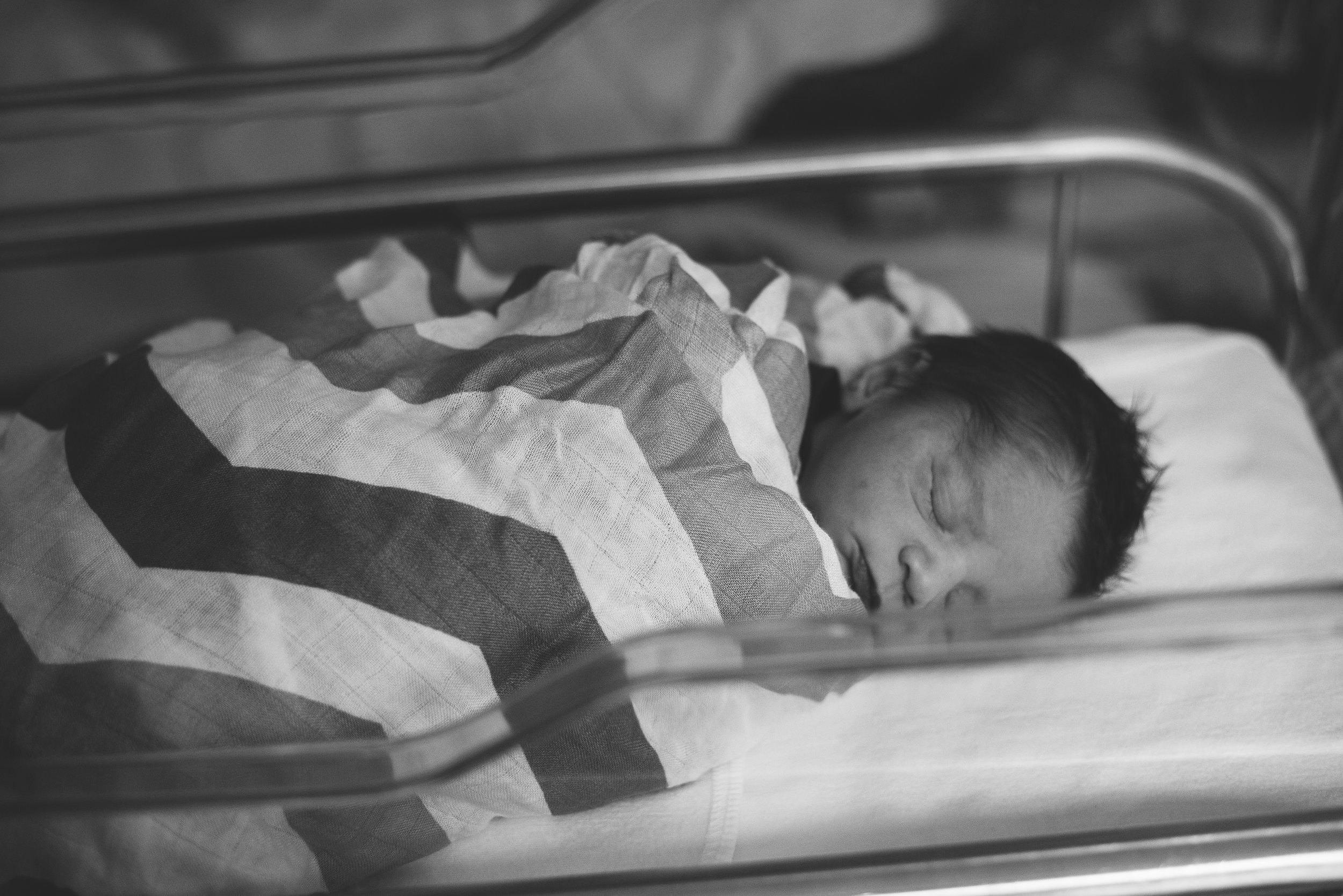 baby sleeping in hospital crib- Pensacola newborn photographer