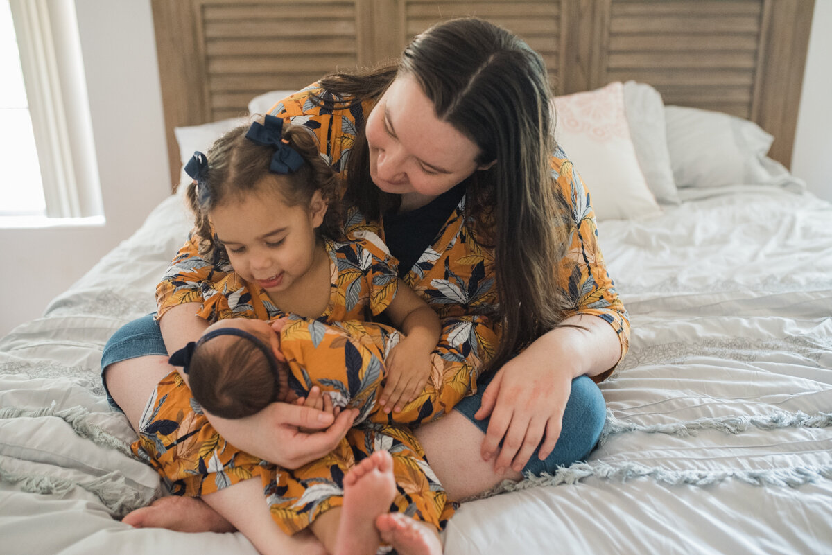 mom with baby and toddler on bed-pensacola newborn photographer