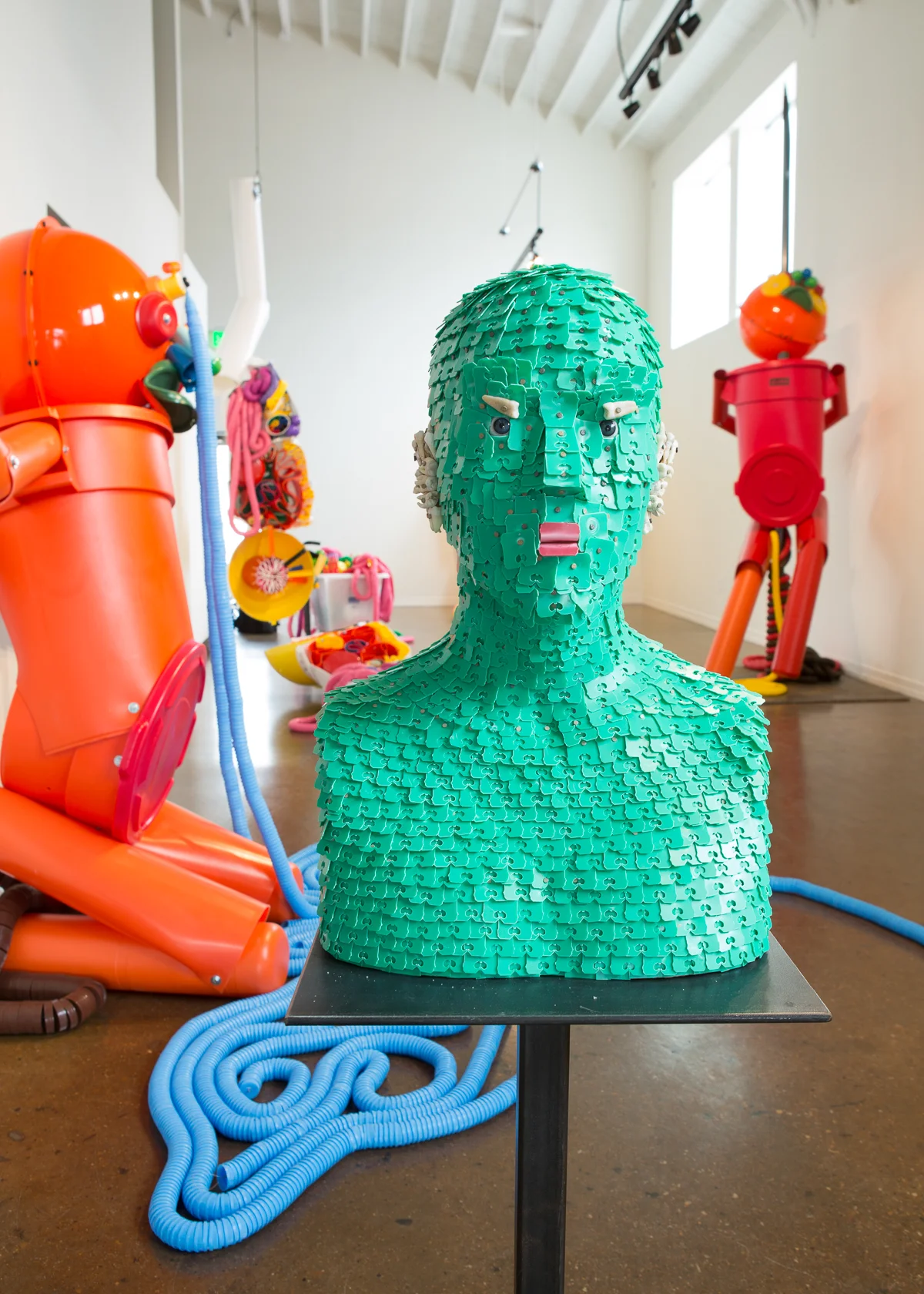 Green Assistant 2016, Mixed media, bread tabs, glass eyeballs, teeth, 19 x 12 x 12 in.