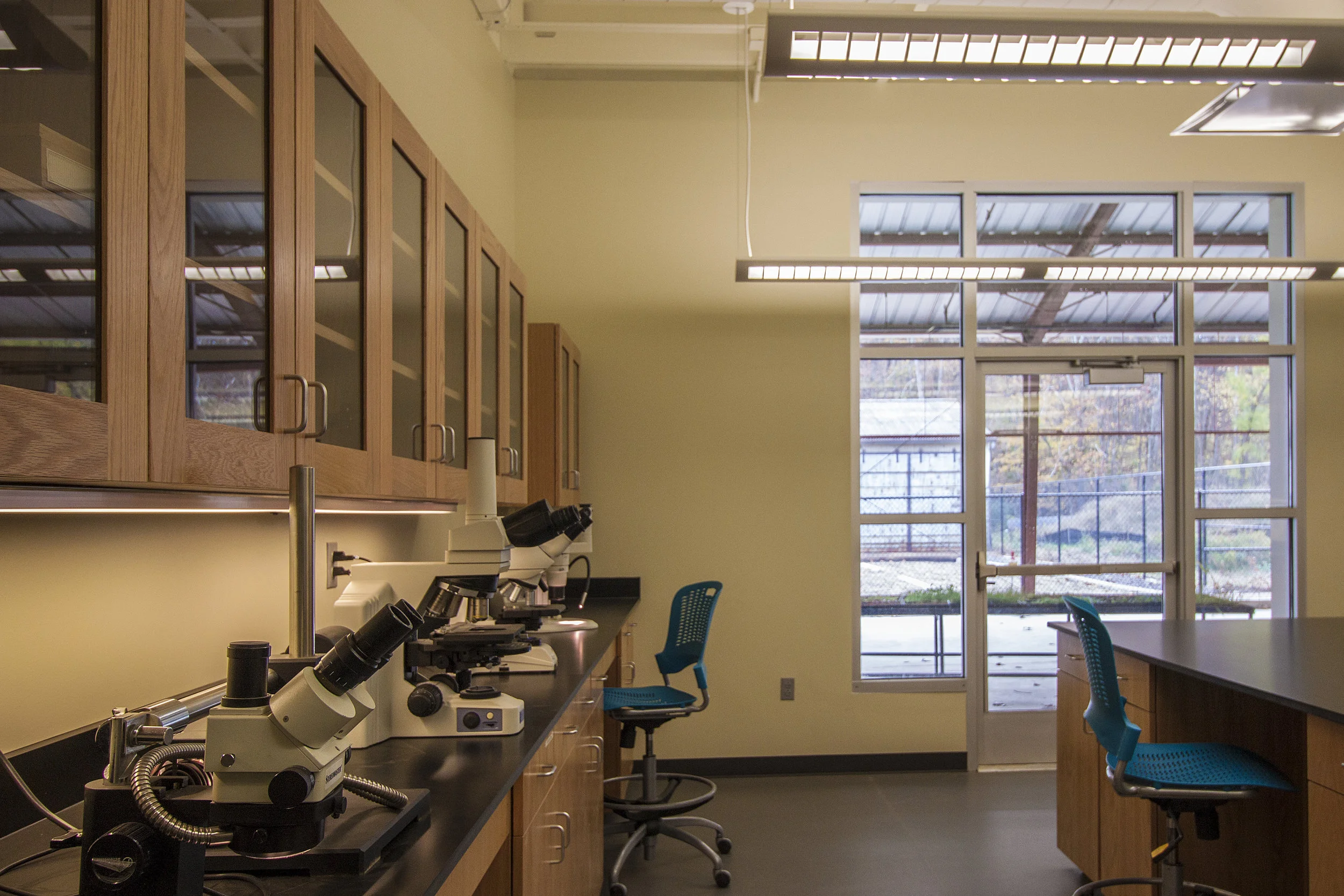 Each of the potential 10 labs is securable from each other and from the outside, allowing for researchers to maintain control over their work and equipment while still sharing the common spaces with other teams. Each lab subspace is designed to be independently lit and temperature controlled. The center casework was custom designed on wheels to allow for each lab to be configured differently. Flooring surfaces in each lab are formed from heat-welded resilient sheets and flow to central drains allowing for complete cleanability.