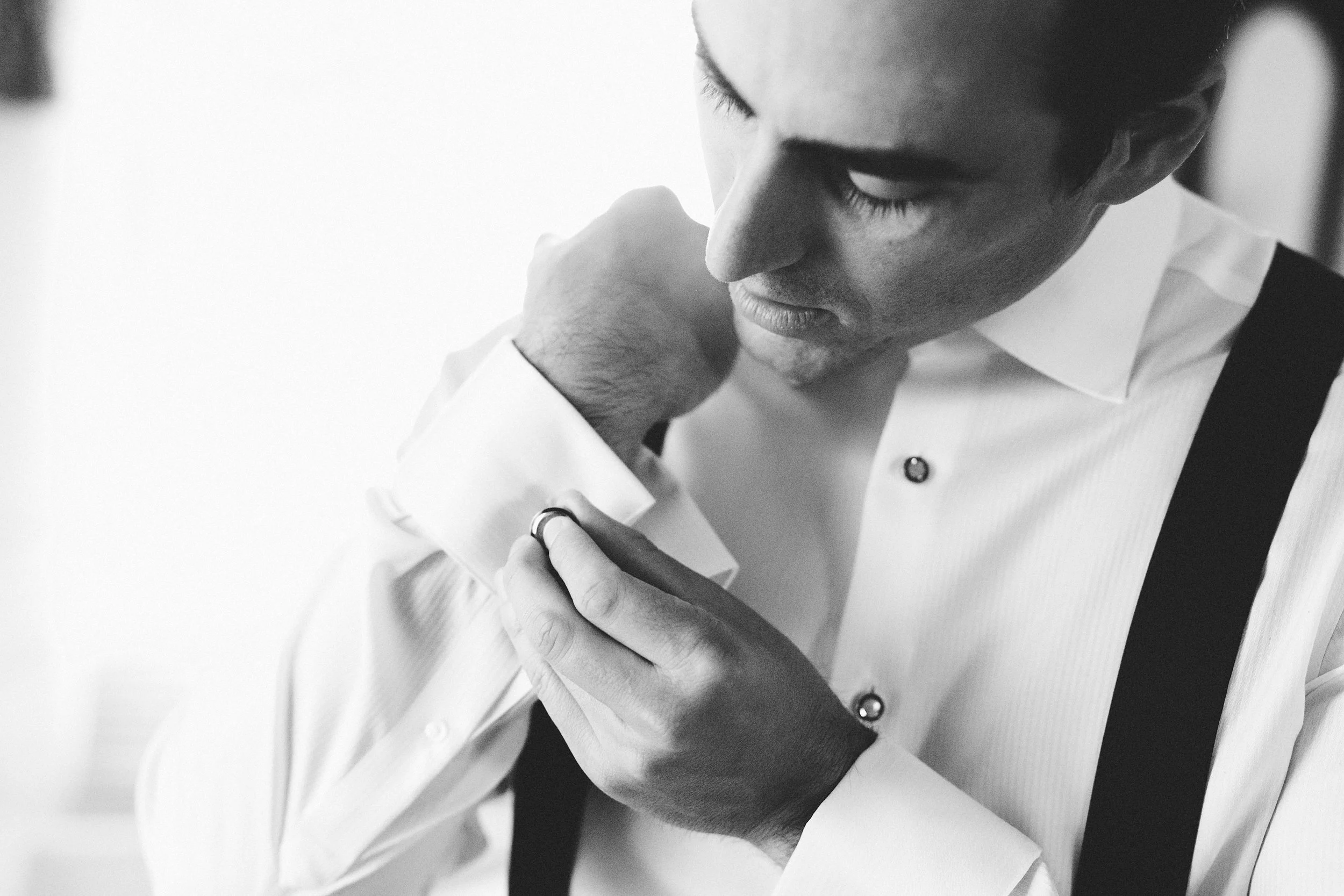 black and white portrait of a groom getting ready