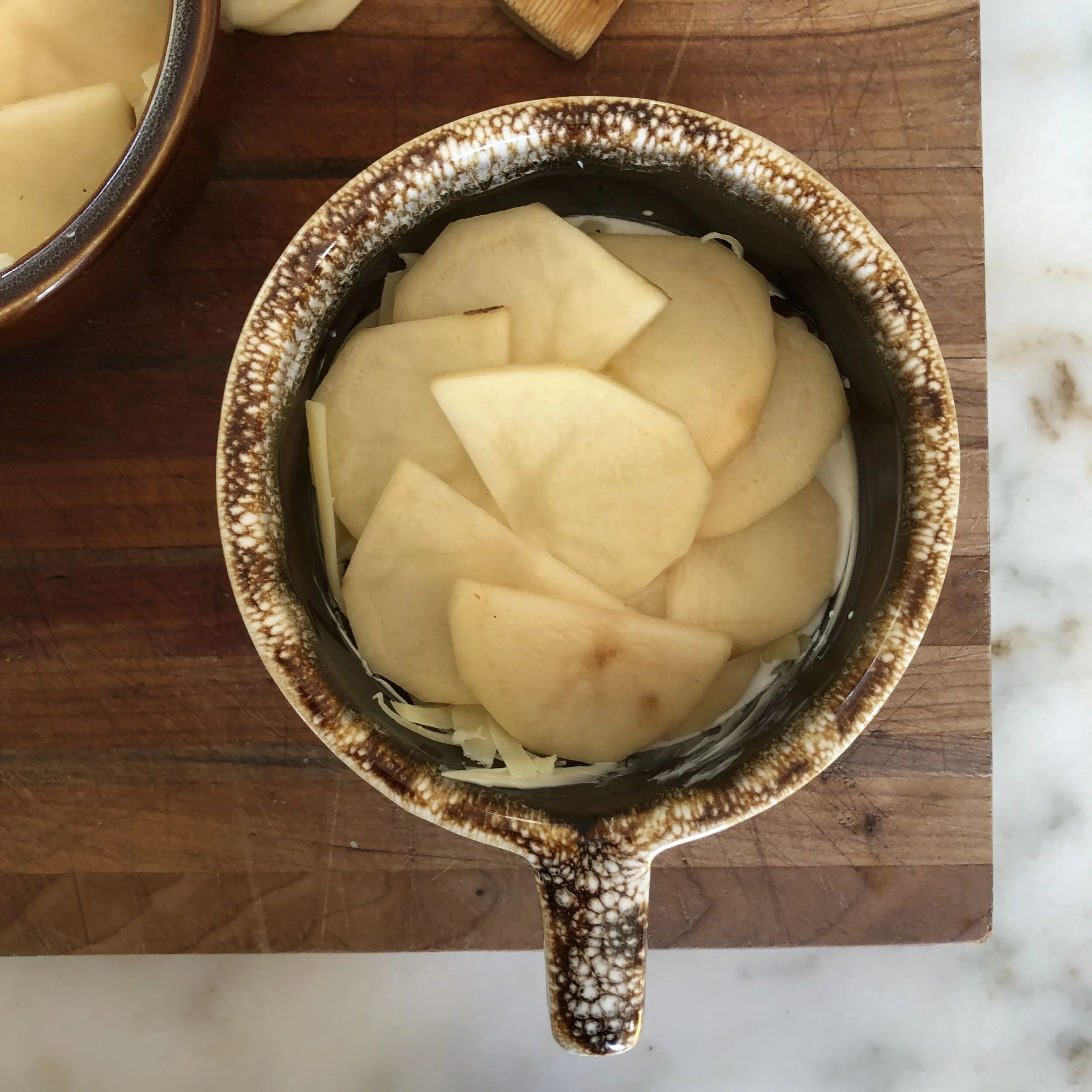 3. Layer your thin-cut potato slices like fish scales