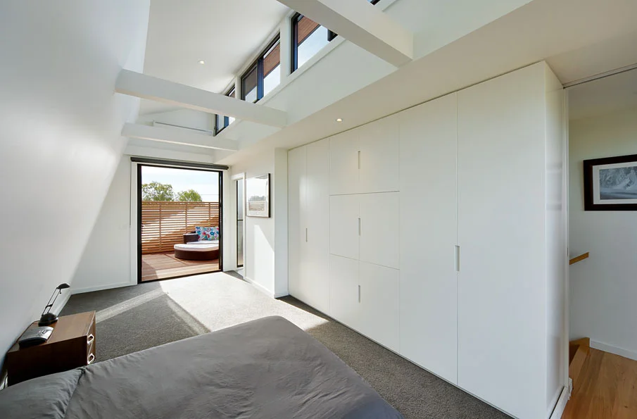 light-filled bedroom with extensive robe space and a private balcony