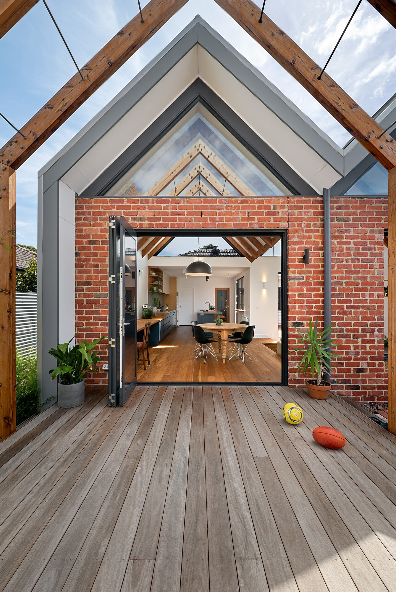 Symmetrical view through the pergola and brick gable entry into the kitchen and dining space beyond