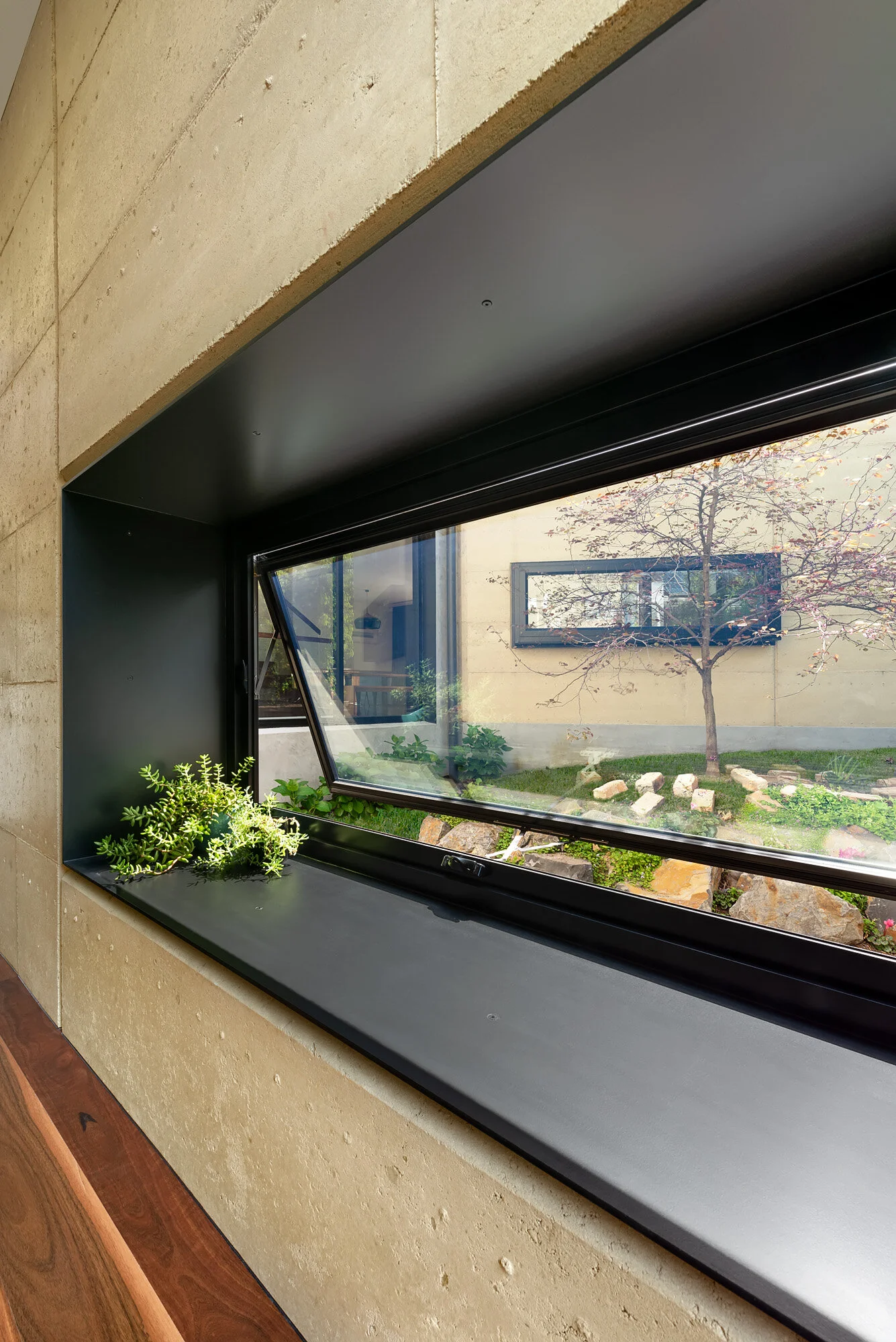 Rammed earth wall with deep window seat looking to central courtyard.