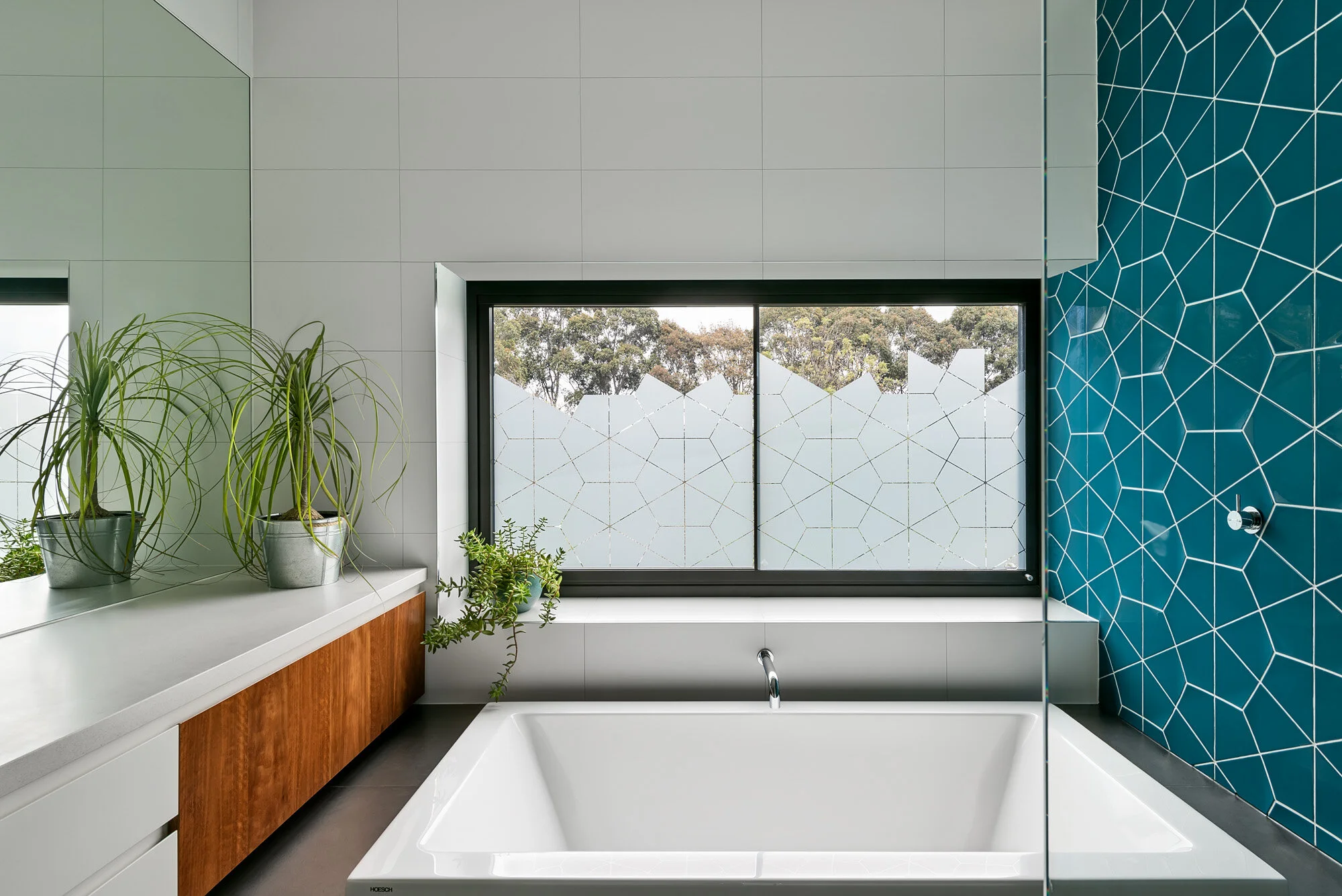 Bathroom with blue cone shaped tiles and timber vanity.