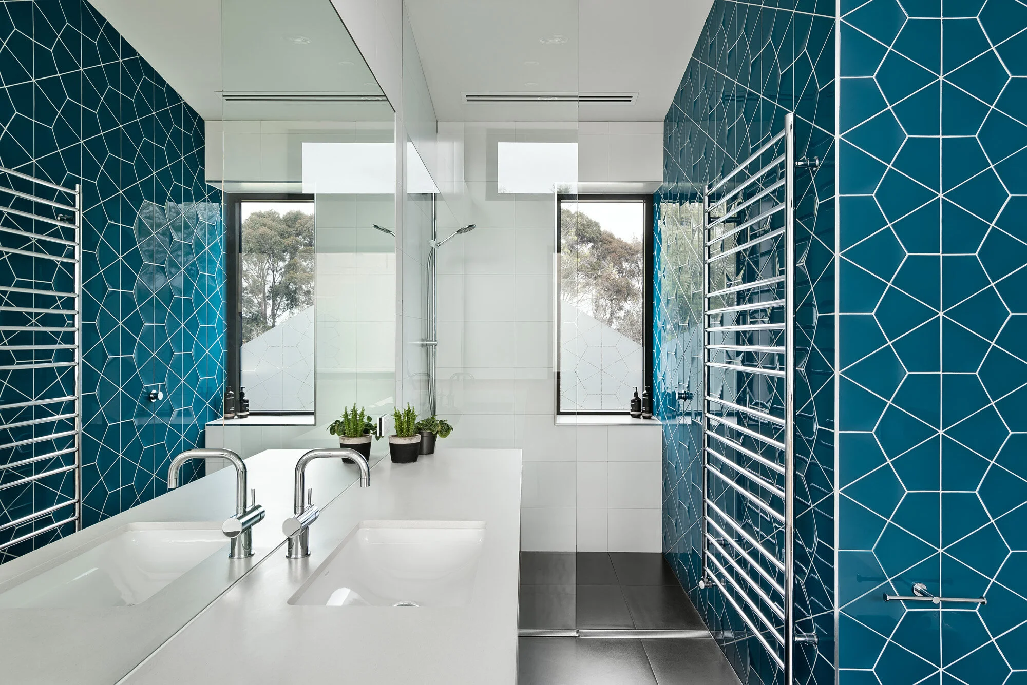 Spacious bathroom with blue hexagonal tiles and views to Yarra River.