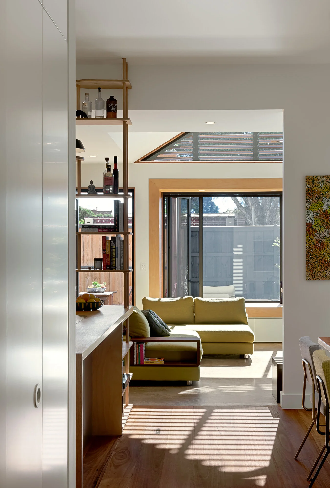 View from the kitchen through to the living room, with glazed doors opening onto the pergola-covered garden