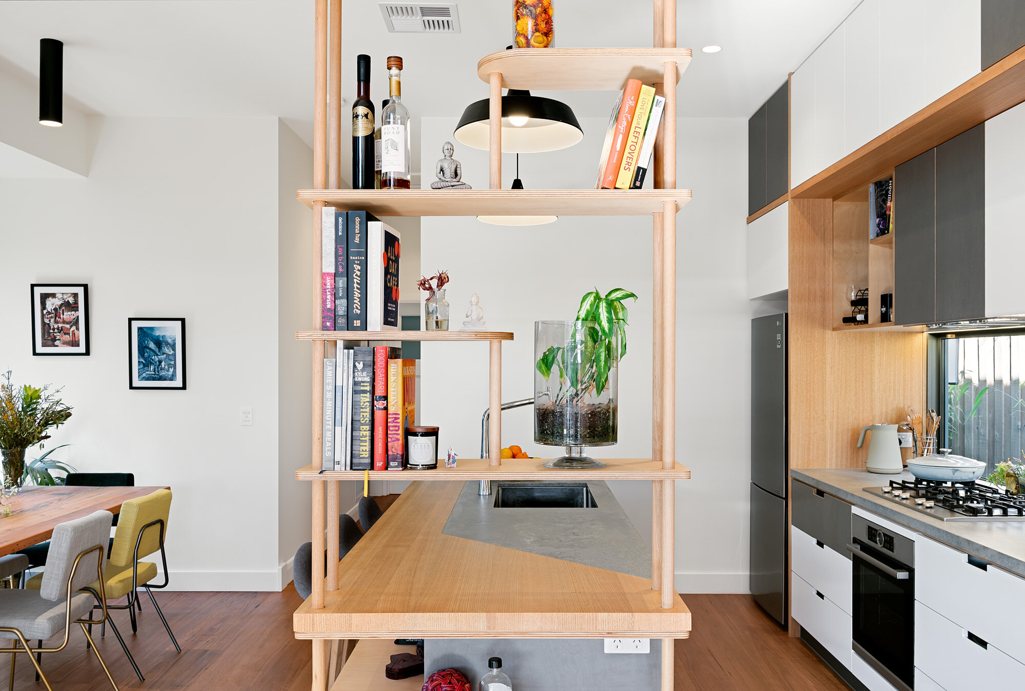 Efficient island galley kitchen with pendant lights and window for natural lighting