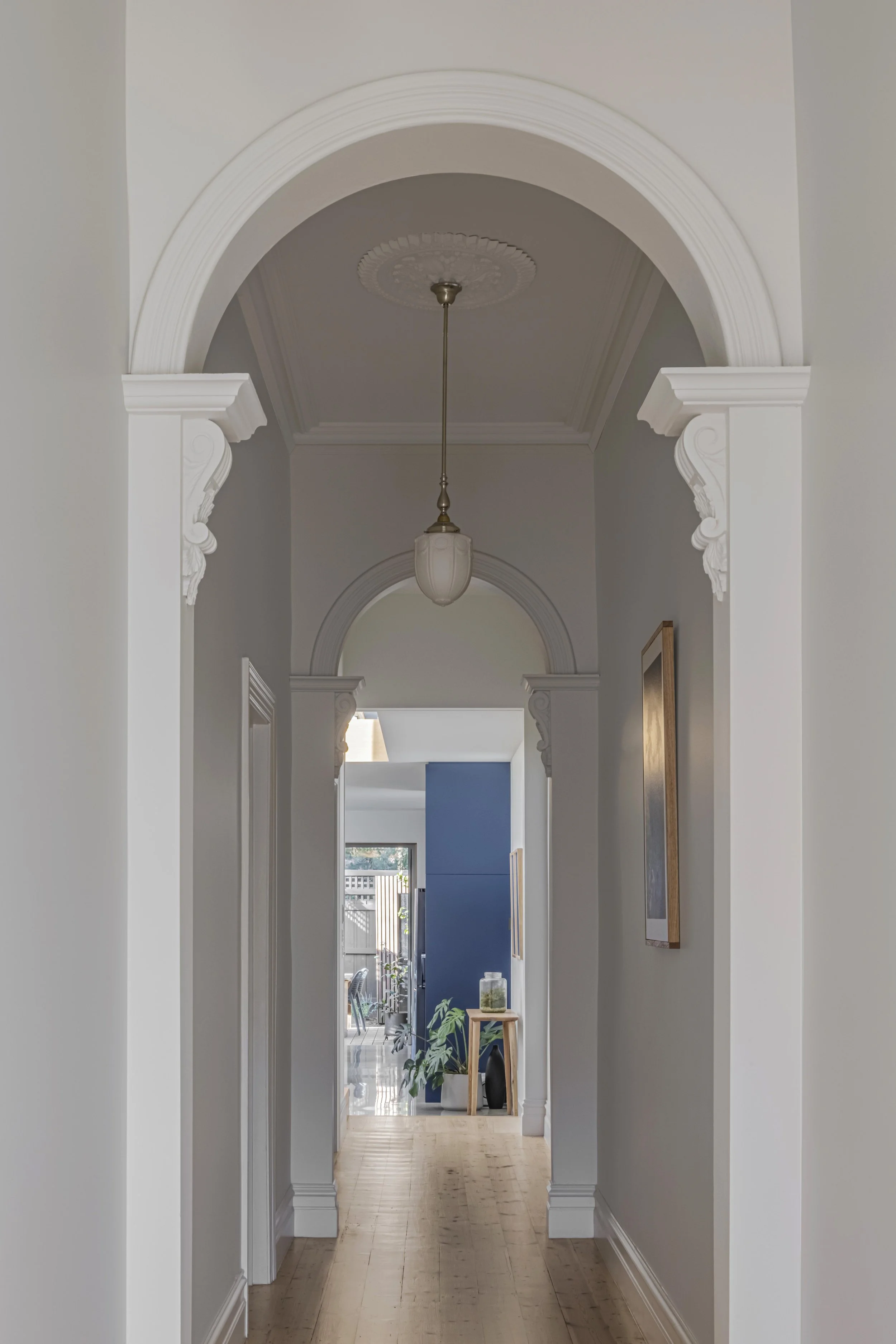 Original Victorian hallway with a decorative archway and ceiling rose, leading through to the home's contemporary rear extension