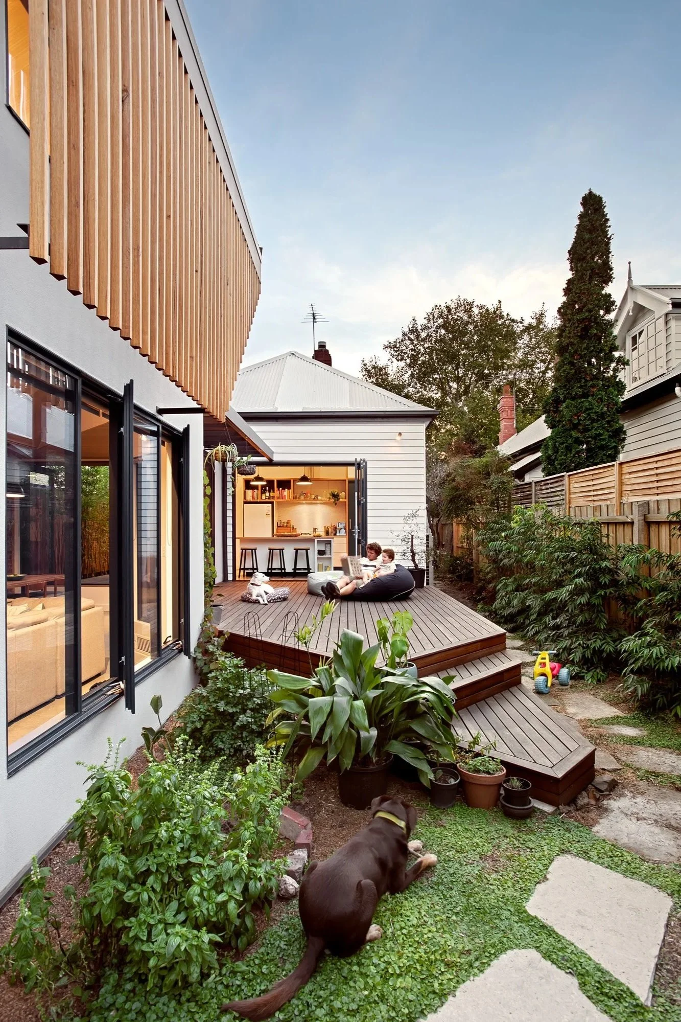 An extension that connects a californian bungalow to a spacious deck and green garden